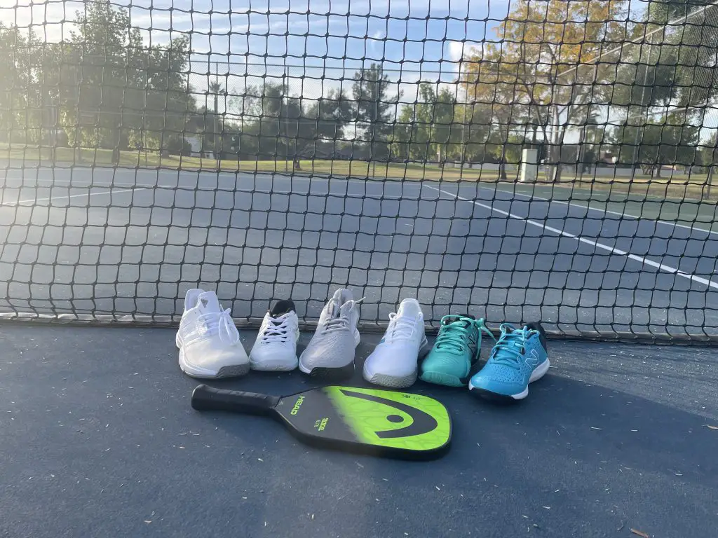 best pickleball shoes of 2022 lined up on a pickleball court with a paddle